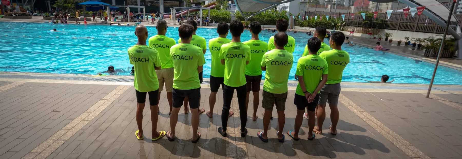 Singapore Swimming Academy coaches lined up at the poolside in COACH team shirts